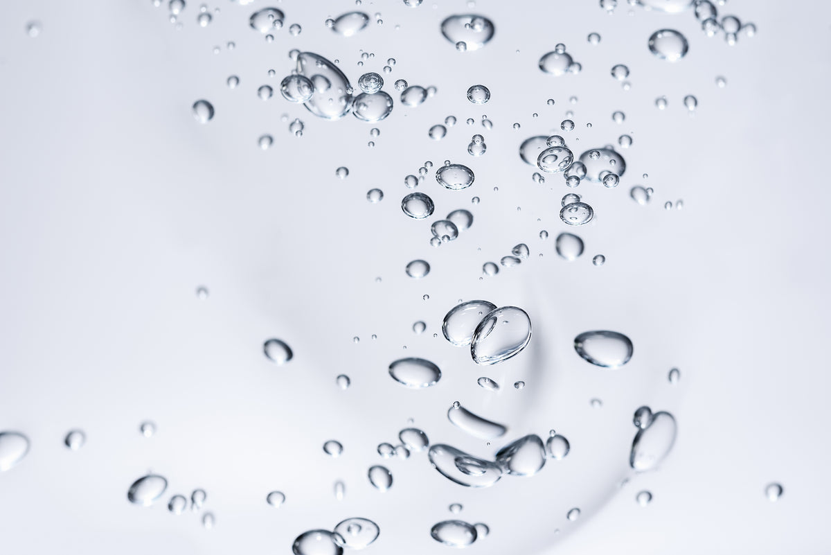 Schwebende Wassertröpfchen auf hellem Hintergrund, frische Hydration