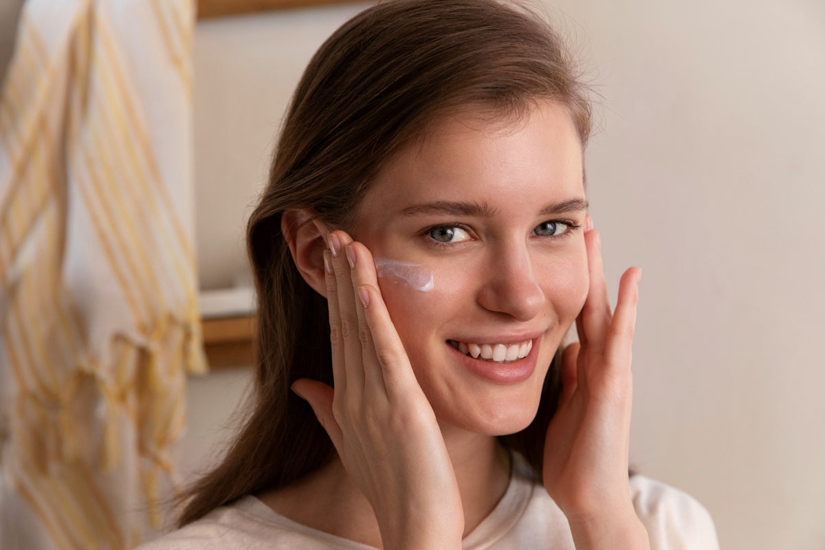 Braunhaarige Frau cremt sich mit Anti UV Fluid ein