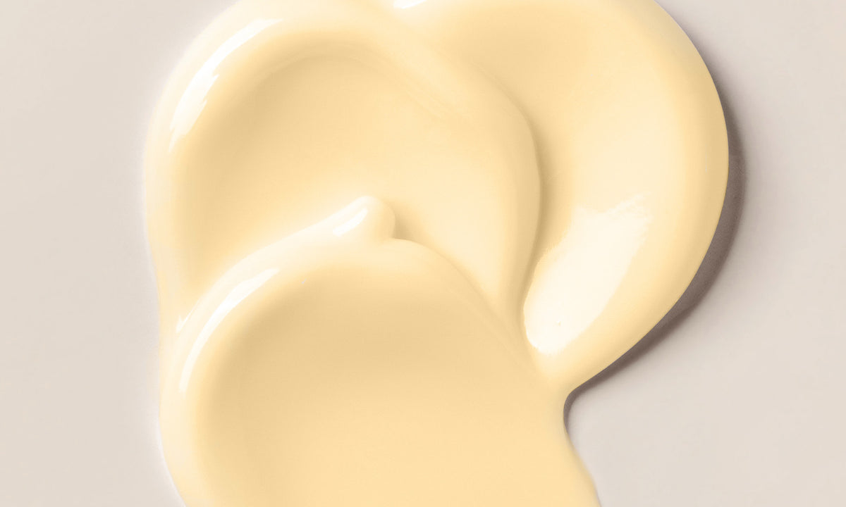 Hellgelbe Cremetextur als Swirl auf hellem Hintergrund, Nahaufnahme