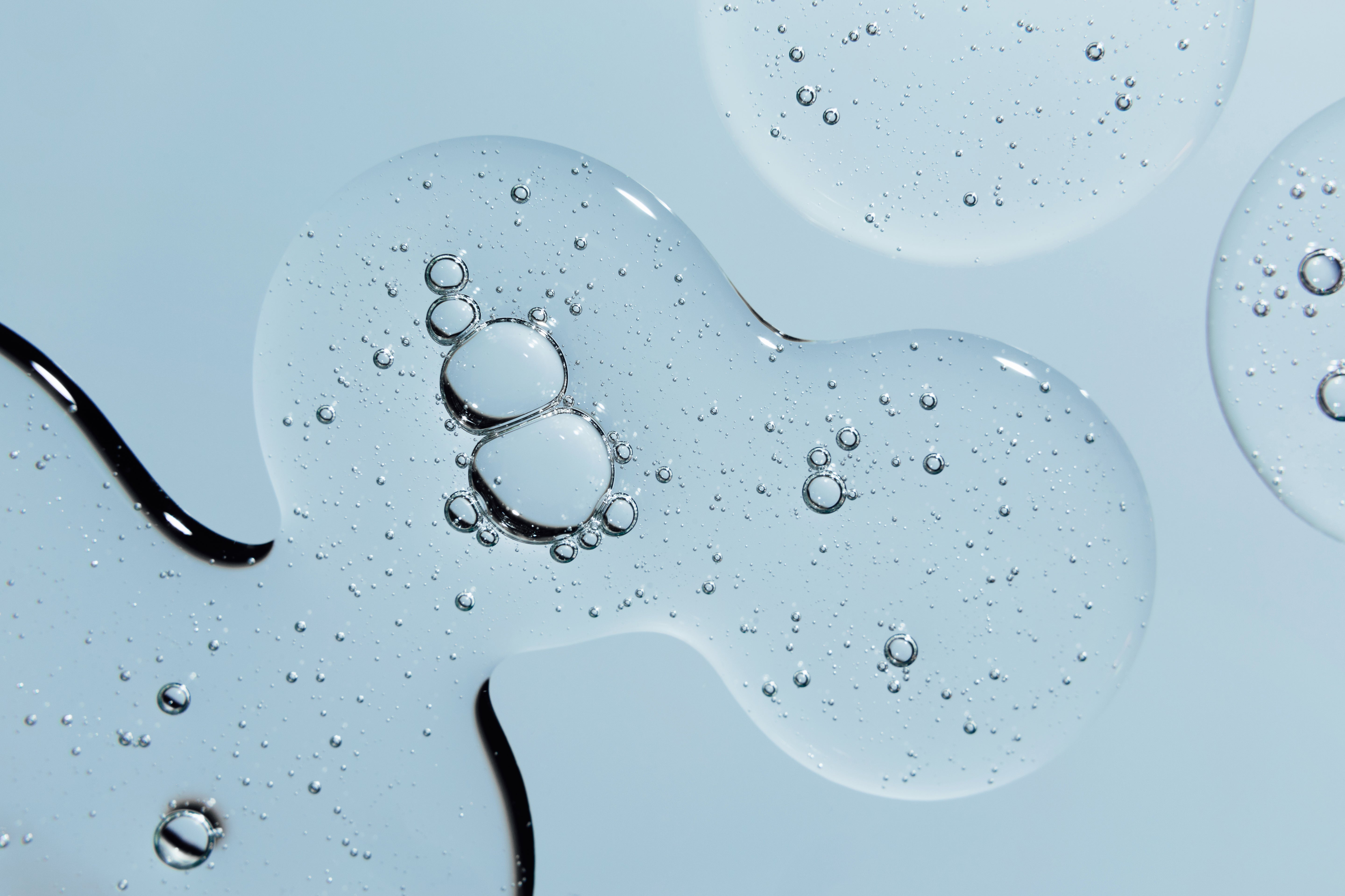 Hyaluronsäure: Serum mit Luftblasen auf einem hellblauen Hintergrund