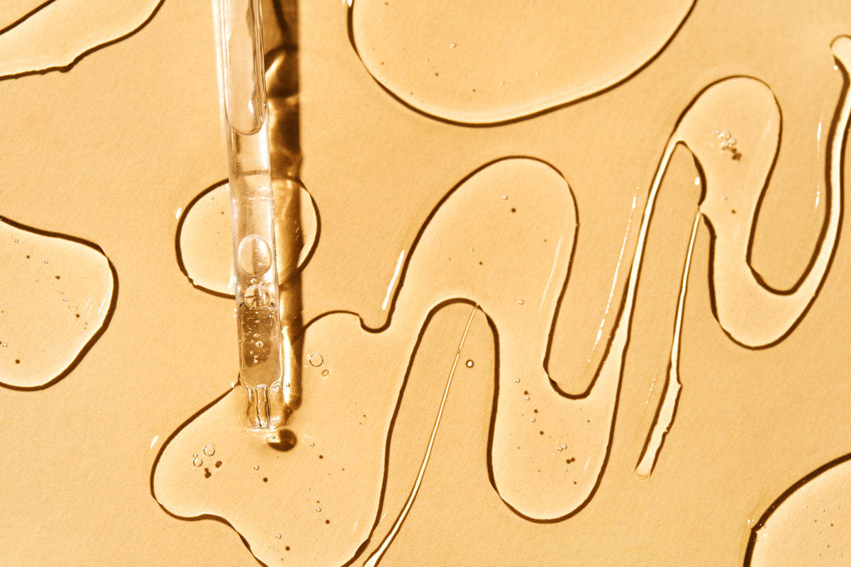 Serum auf goldenem Hintergrund mit Pipette
