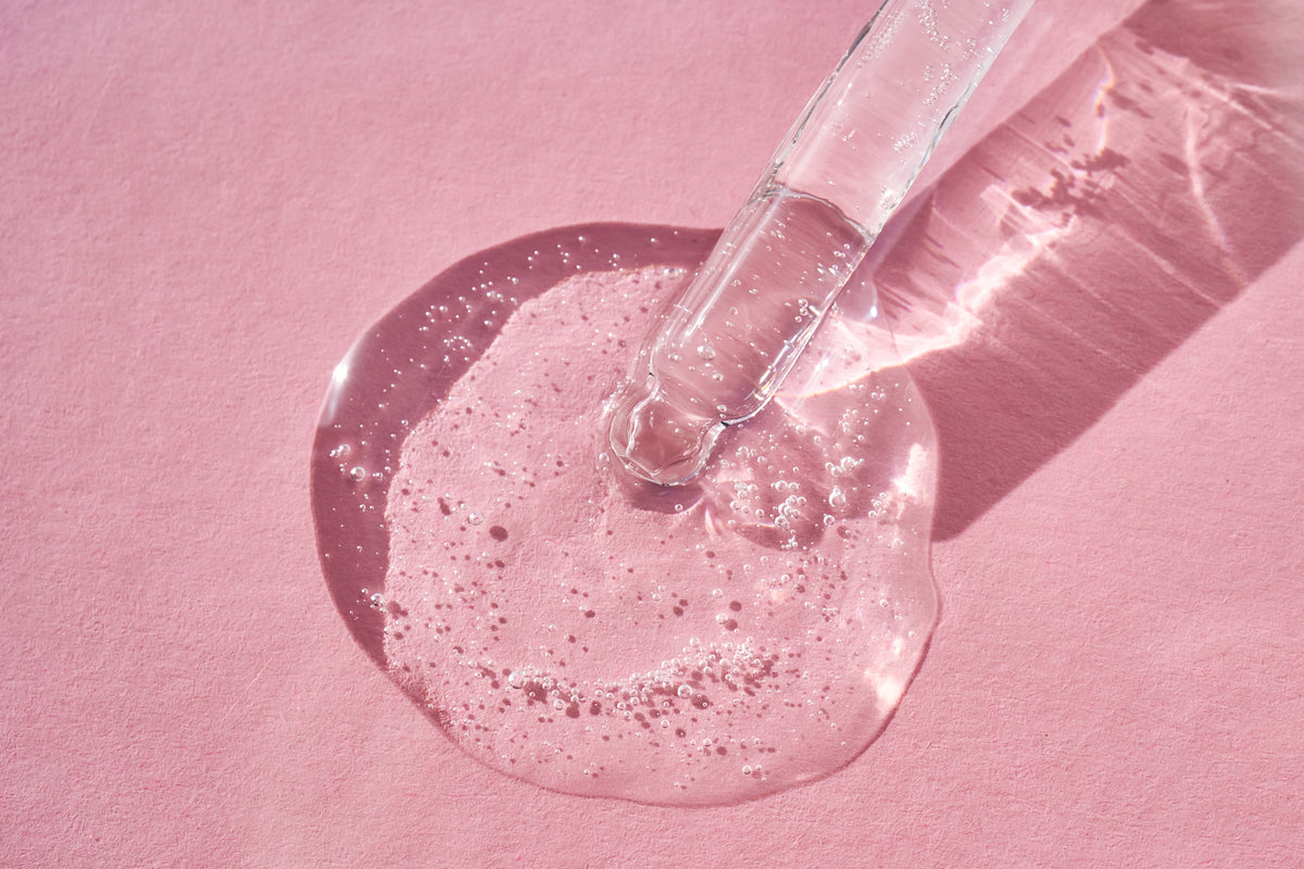 klares Serum auf einem pinken Hintergrund