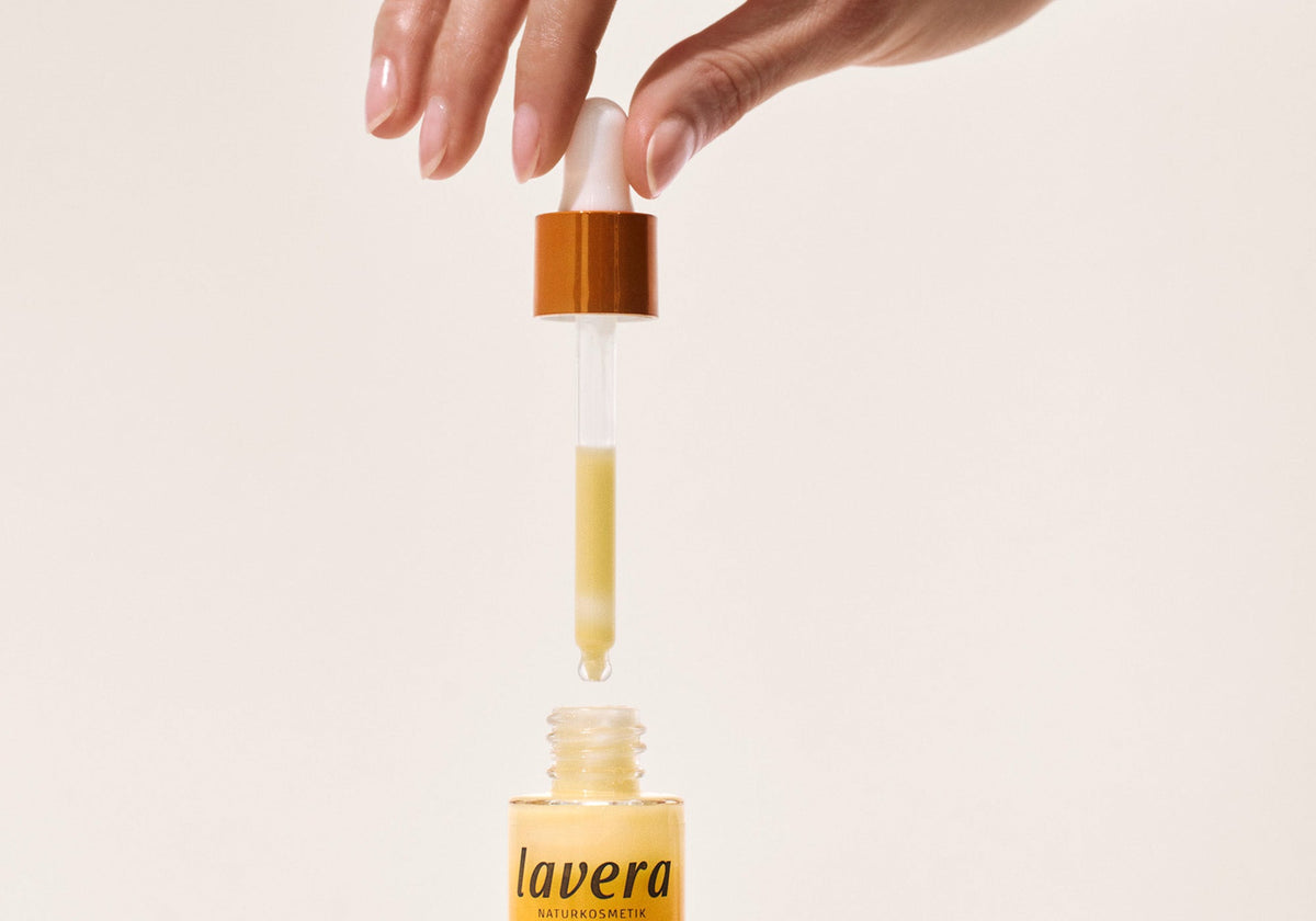 Hand entnimmt mit Pipette gelbe Flüssigkeit eines lavera Serums