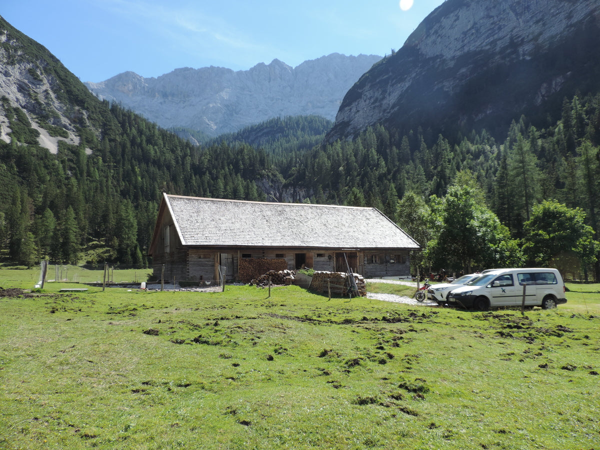 Almhütte aus Holz in den Bergen bei Sonnenschein