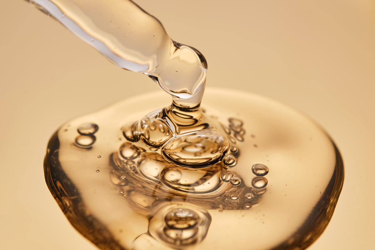 goldenes Serum, das aus einer Pipette tropft